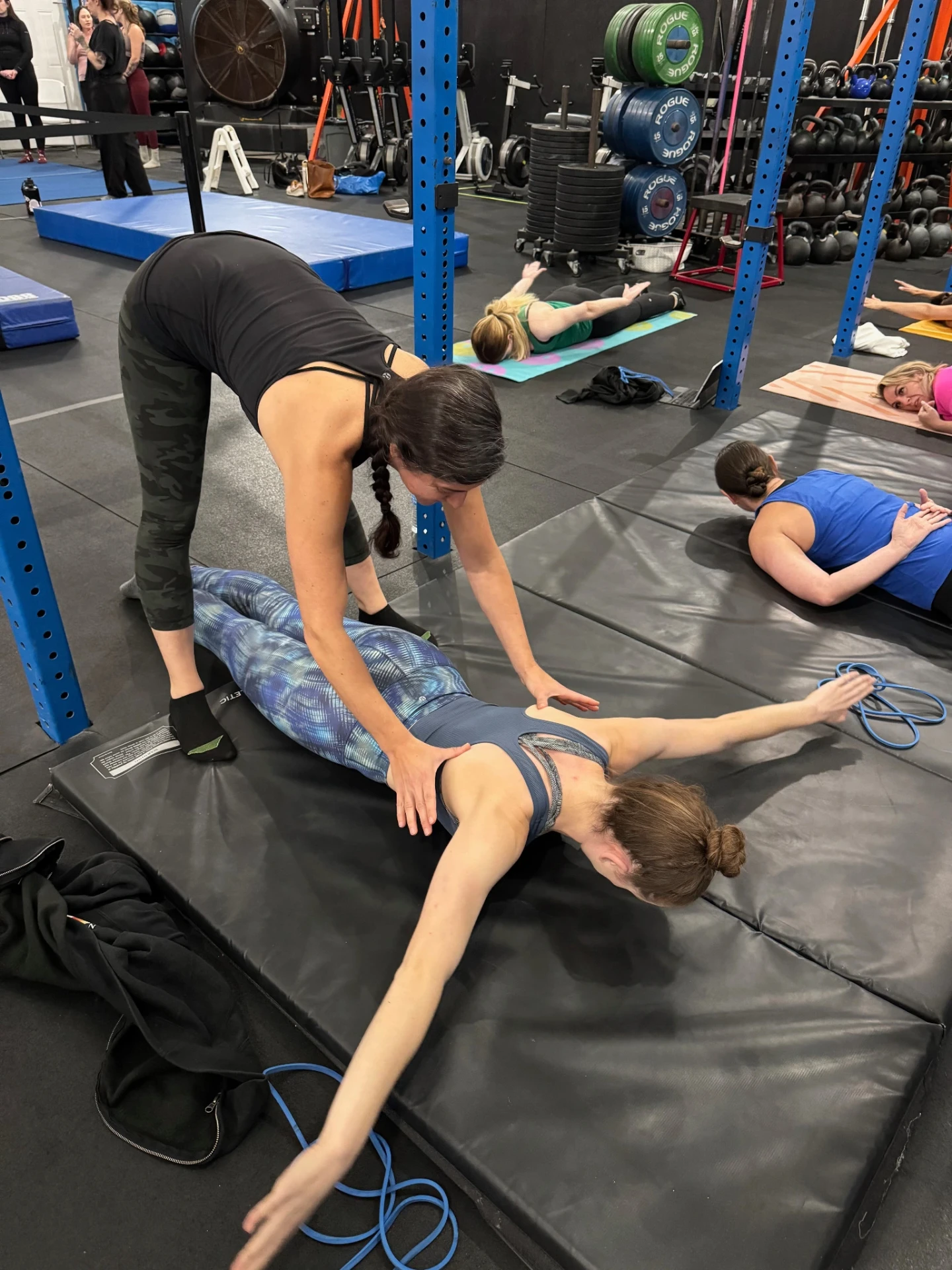 Students practicing coached flexibility and conditioning drills on mats at Dallas Circus Center